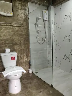 a bathroom with a toilet and a glass shower at THE HOG in Bangkok Yai