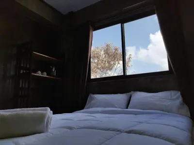 a bedroom with a bed with a large window at THE HOG in Bangkok Yai