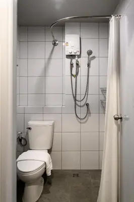a bathroom with a toilet and a shower at Stay Wanglang in Bangkok