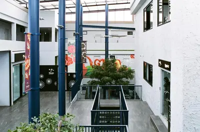 an empty hallway with blue poles and a plant at Stay Wanglang in Bangkok