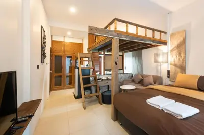 a bedroom with a loft bed and a desk at Tepbunthom Hostel in Bangkok