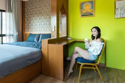 a woman sitting at a desk in a hotel room at Tepbunthom Hostel in Bangkok