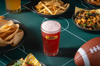 a table topped with plates of food and a glass of beer at Holiday Inn Bangkok by IHG in Bangkok