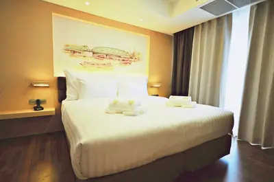 a hotel room with a bed with two towels on it at Parinda Hotel in Bangkok