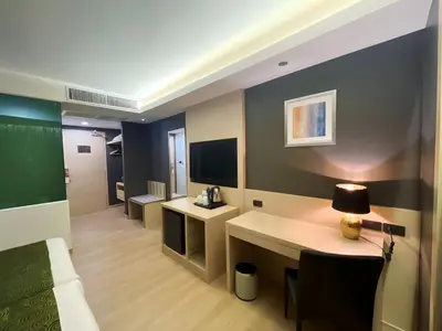 a room with a bed and a desk and a tv at iCheck inn Nana by Aspira in Bangkok