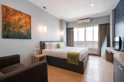 a hotel room with a bed and a tv at iCheck inn Gems Center Silom in Bangkok