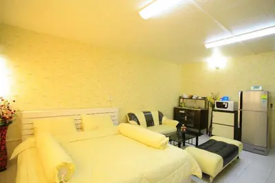 a bedroom with a large bed and a refrigerator at Deluxe at Popular Condo in Bangkok