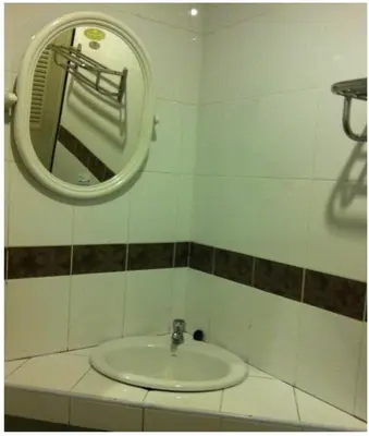 a bathroom with a sink and a mirror at Orchid Place in Bangkok
