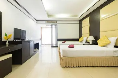 a bedroom with two beds and a flat screen tv at The Legacy Convention Hotel in Nonthaburi