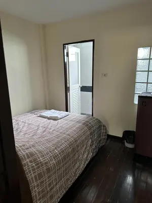 a bedroom with a bed and a large mirror at Orchid House in Bangkok