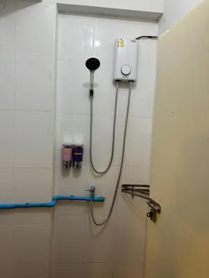 a shower in a bathroom with a hose on the wall at Orchid House in Bangkok