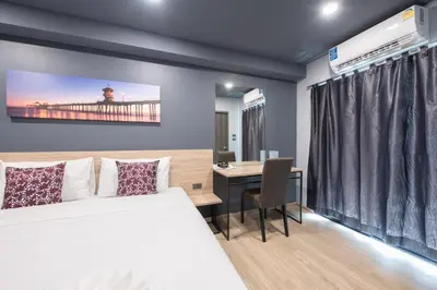 a bedroom with a bed and a desk with a computer at Oblique Apartment - ออฟบลิค อพาร์ทเมนท์ in Nonthaburi
