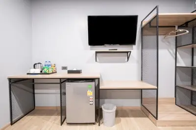 a room with a desk and a tv and a refrigerator at Oblique Apartment - ออฟบลิค อพาร์ทเมนท์ in Nonthaburi