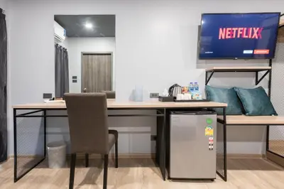 an office with a desk with a television on it at Oblique Apartment - ออฟบลิค อพาร์ทเมนท์ in Nonthaburi