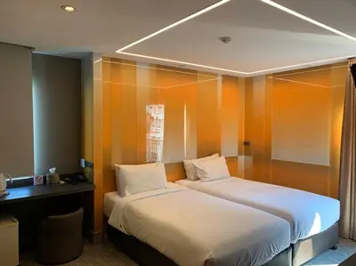 a hotel room with two beds and a desk at Tango Vibrant Living Hotel - SHA Extra Plus in Bangkok