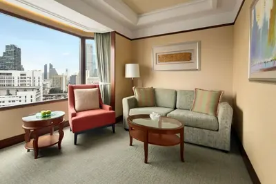 a hotel room with a couch and a chair and a window at Shangri-La Bangkok in Bangkok