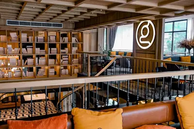 a library with a couch and shelves of books at Graph Hotels Bangkok in Bangkok