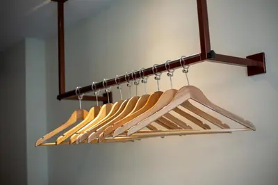 a rack of wooden hangers in a closet at Lemontea Hotel Bangkok in Bangkok