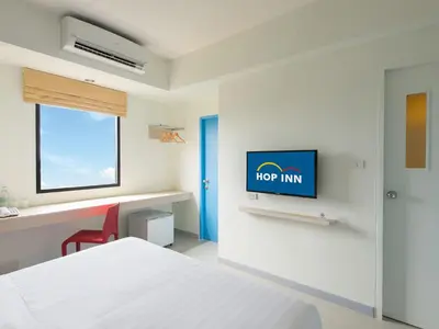 a bedroom with a bed and a tv on a wall at HOP INN Chaengwattana in Nonthaburi