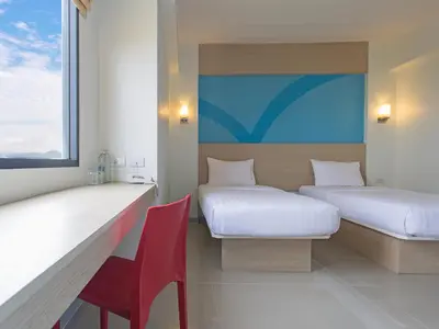 a room with two beds and a red chair at HOP INN Chaengwattana in Nonthaburi