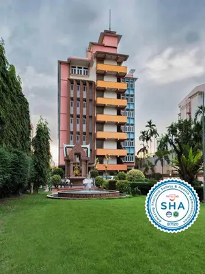 a large building with a fountain in front of it at Capital Mansion - SHA Certified in Bangkok