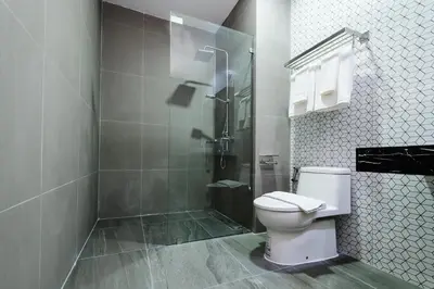 a bathroom with a toilet and a shower at College Haus Rangnam in Bangkok