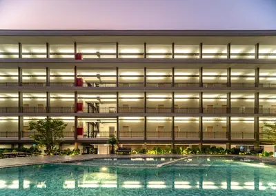 an exterior view of a building with a swimming pool at College Haus Rangnam in Bangkok