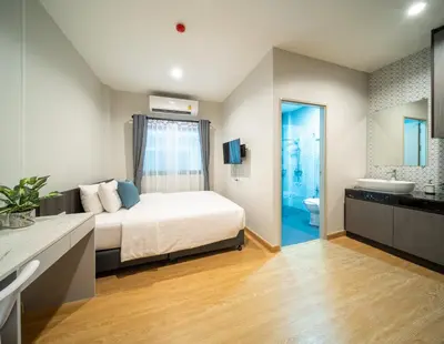 a bedroom with a bed and a bathroom at College Haus Rangnam in Bangkok