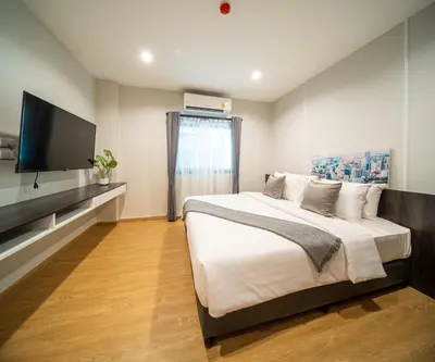 a bedroom with a large bed and a flat screen tv at College Haus Rangnam in Bangkok