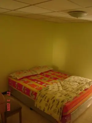 a bed sitting in a corner of a room at Kaset Guesthouse in Bangkok