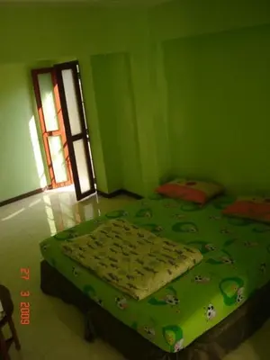 a green bedroom with a bed in a room at Kaset Guesthouse in Bangkok