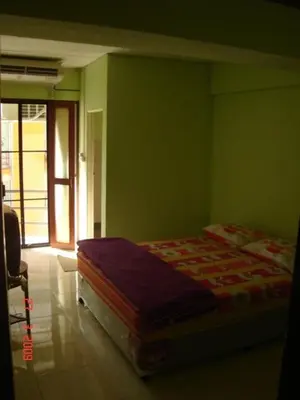a bedroom with a bed in a green wall at Kaset Guesthouse in Bangkok
