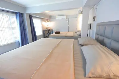 a large bedroom with two beds and two windows at Baankhon Private room in Thai house Check in by yourself code inbox Adult Only in Bangkok