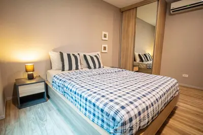 a small bedroom with a bed and a mirror at Blossom Sathon Condo in Bangkok