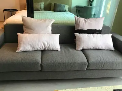 a couch with pillows on it in a bedroom at CBD Asoke/Nana/Ploenchit +2 mins to Terminal 21 in Bangkok