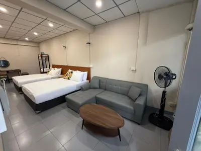 a hotel room with a couch and a bed and a fan at Achcha hotel - itsaraphap MRT station - Wat Arun in Bangkok