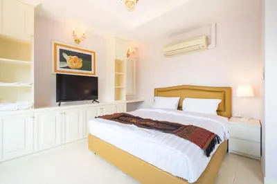 a bedroom with a bed and a flat screen tv at Baan Anodat in Ban Bang Phai