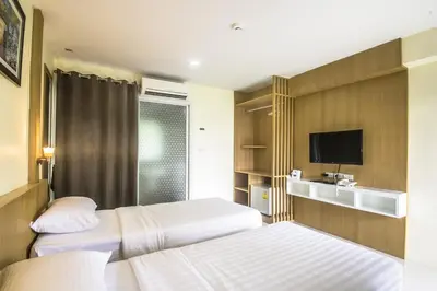 a hotel room with two beds and a tv at Petchsiri Boutique Hotel เพชรสิริ บูทิค in Bangkok