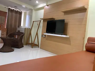 a living room with a flat screen tv on a wall at Petchsiri Boutique Hotel เพชรสิริ บูทิค in Bangkok