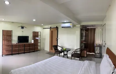 a bedroom with a bed and a television and a table at Petchsiri Boutique Hotel เพชรสิริ บูทิค in Bangkok