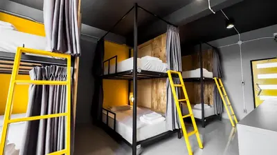 a room with three bunk beds with yellow ladder at Room 22 Hostel - near Chinatown in Bangkok