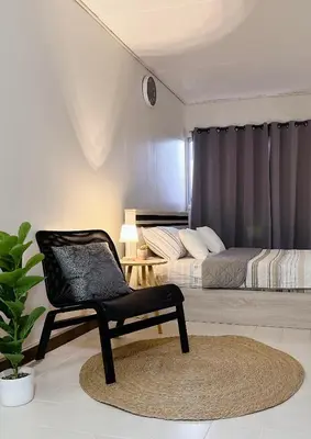 a black chair in a bedroom with a bed at Condo Popular T4 Impact Muangthong by Tide in Pak Kret