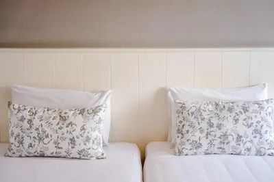 two white pillows sitting on top of a bed at Cinnamon Hotel Bangkok in Bangkok