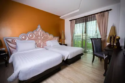 a bedroom with two beds and a large window at Chillax Resort in Bangkok