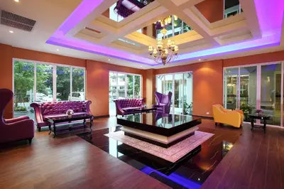 a living room with colorful furniture and a coffered ceiling at Chillax Resort in Bangkok