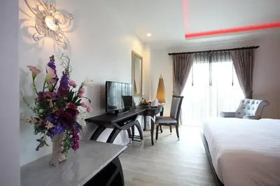 a hotel room with a bed and a vase of flowers at Chillax Resort in Bangkok
