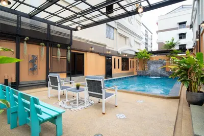 a patio with a pool and chairs and a table at P-Park Hotel Bangkok in Bangkok