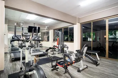 a gym with several treadmills and elliptical machines at P-Park Hotel Bangkok in Bangkok