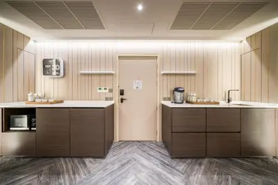 a kitchen with wooden cabinets and a door in a room at Triple Y Hotel in Bangkok
