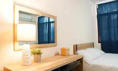 a bedroom with a mirror and a table with a bed at INN Room in Bangkok